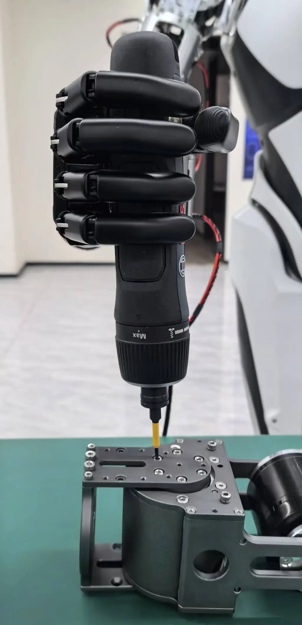 Robotic hand using an electric screwdriver on a metal assembly